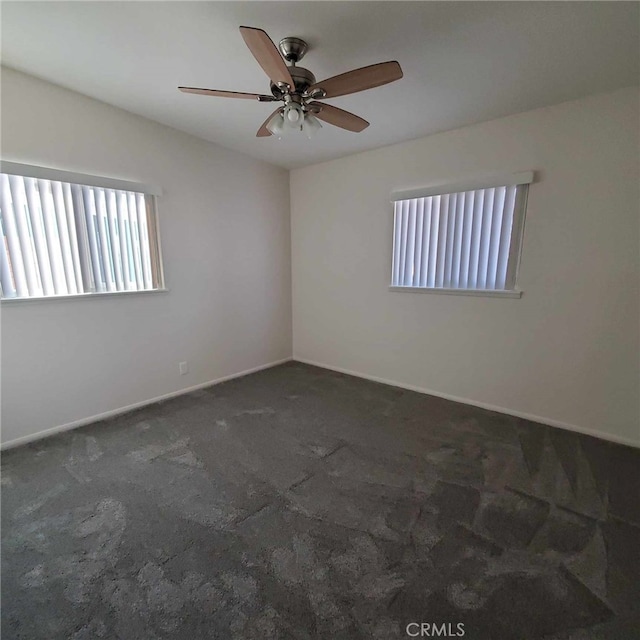 carpeted spare room featuring ceiling fan