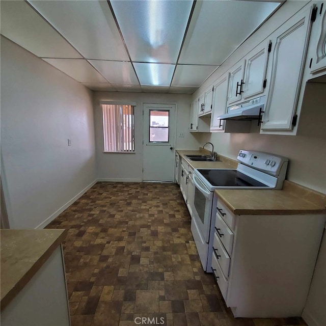 kitchen featuring electric stove, sink, and white cabinetry