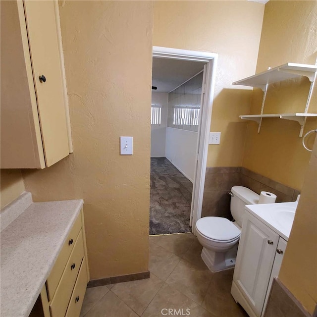 bathroom featuring vanity, tile patterned floors, and toilet