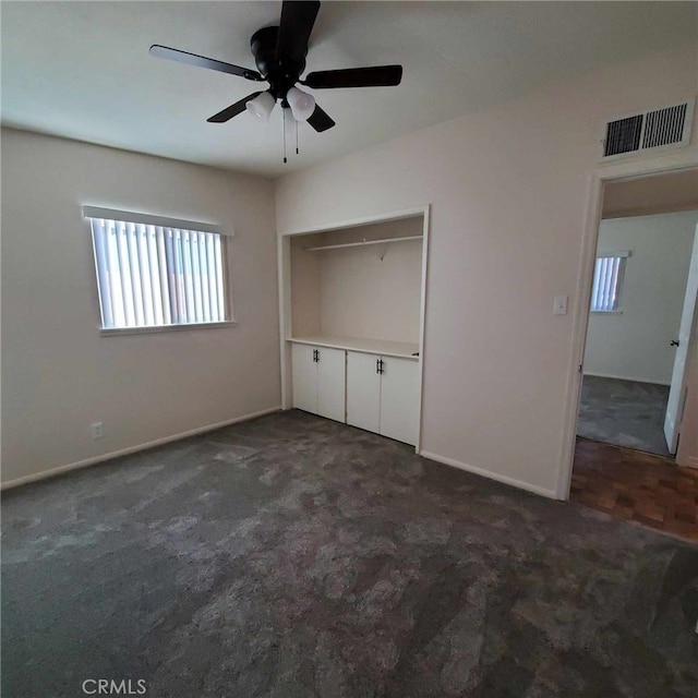 unfurnished bedroom featuring a closet, ceiling fan, and dark colored carpet