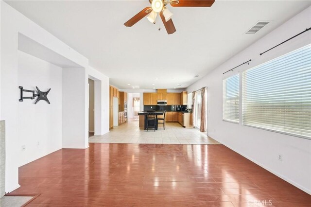 unfurnished living room with ceiling fan and light hardwood / wood-style flooring