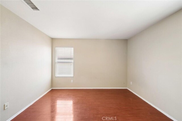 unfurnished room with hardwood / wood-style flooring