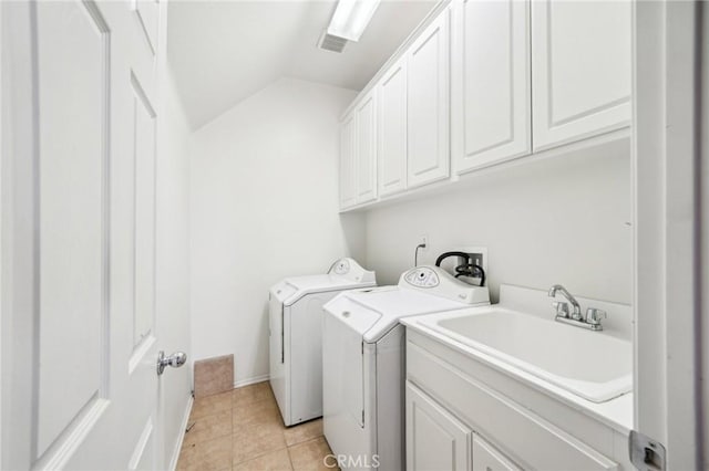 laundry area with cabinets, washing machine and clothes dryer, sink, and light tile patterned floors