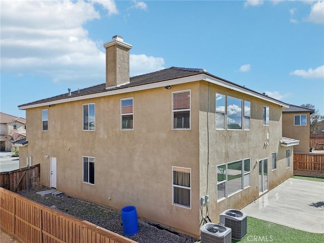 view of side of property with cooling unit and a patio area