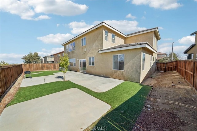 rear view of property with a yard and a patio