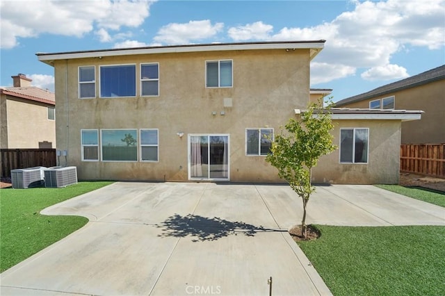 back of house with central AC unit, a patio area, and a lawn