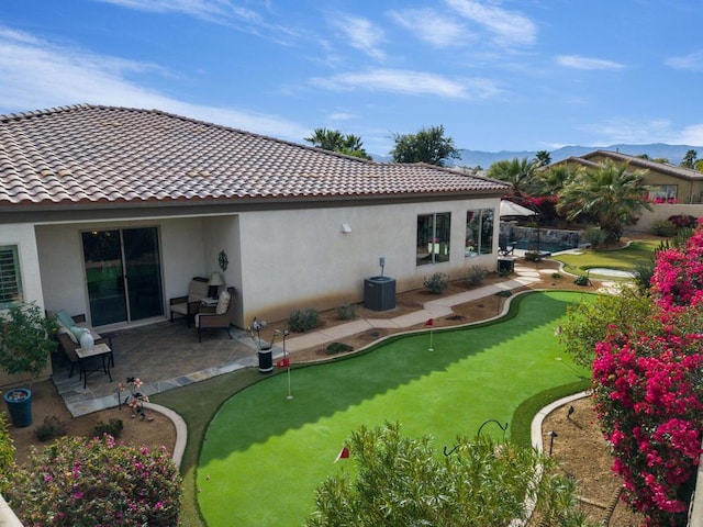 back of property with central AC unit and a patio area