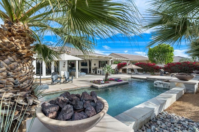 view of pool featuring french doors, a patio area, and an outdoor fire pit