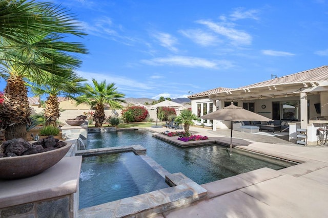 view of swimming pool with an in ground hot tub, pool water feature, and a patio