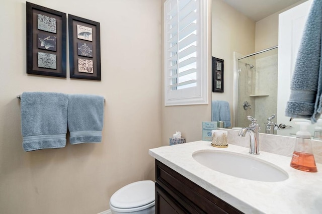 bathroom featuring vanity, toilet, and a shower