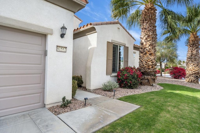 doorway to property featuring a yard and a garage