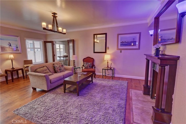 living room featuring an inviting chandelier, ornamental molding, and hardwood / wood-style floors