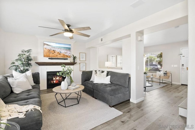 living room featuring light hardwood / wood-style flooring and ceiling fan