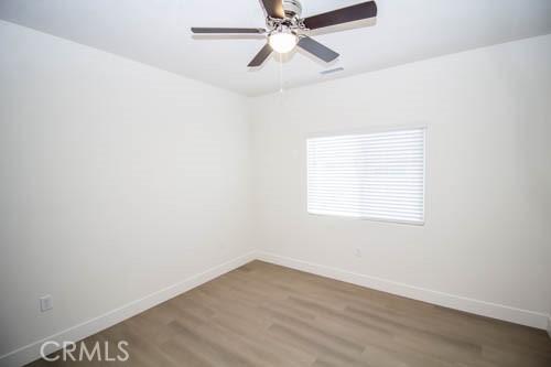 spare room with ceiling fan and wood-type flooring