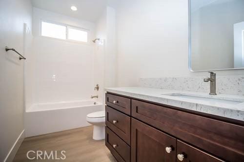 full bathroom featuring vanity, wood-type flooring,  shower combination, and toilet