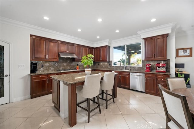 kitchen featuring light tile patterned flooring, appliances with stainless steel finishes, a kitchen island, and dark stone counters