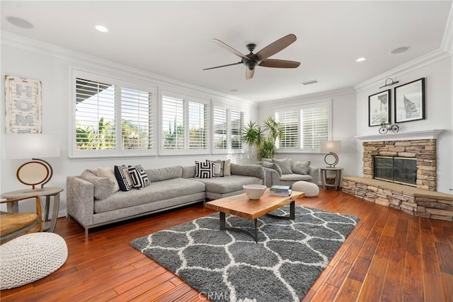 living room featuring crown molding, a fireplace, hardwood / wood-style floors, and a wealth of natural light