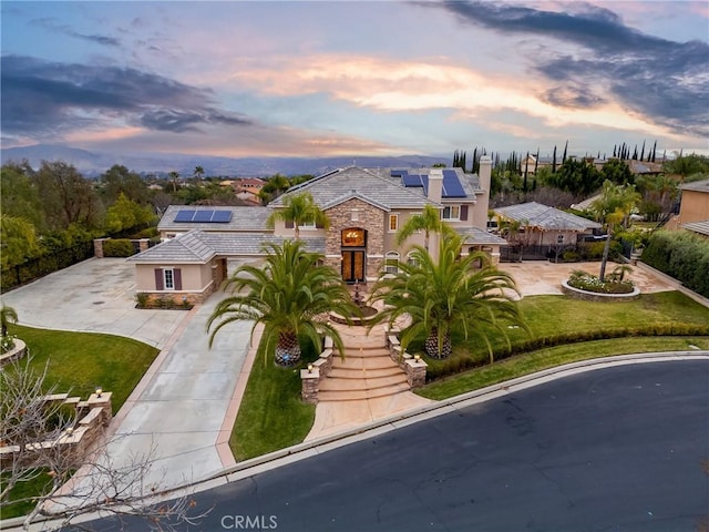 mediterranean / spanish-style home featuring a yard and solar panels