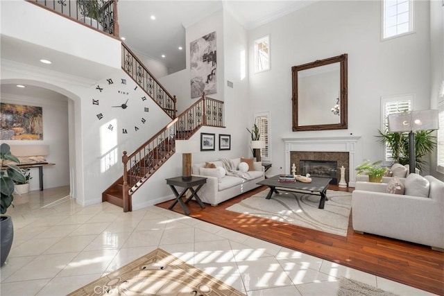 living room with crown molding, a towering ceiling, and light tile patterned floors