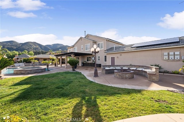 back of house featuring a fire pit, a pergola, a yard, a patio area, and a mountain view