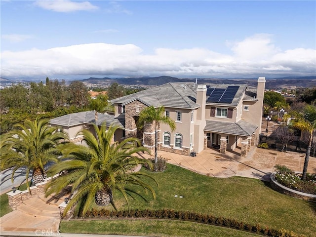 exterior space featuring a front yard and solar panels