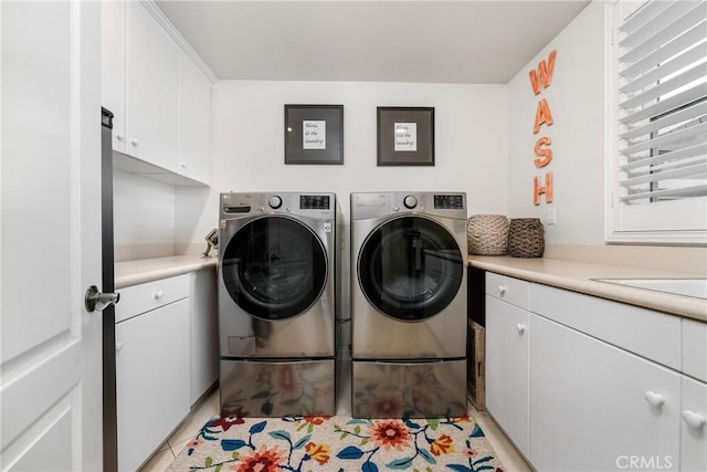 laundry room featuring cabinets, light tile patterned floors, sink, and washing machine and clothes dryer