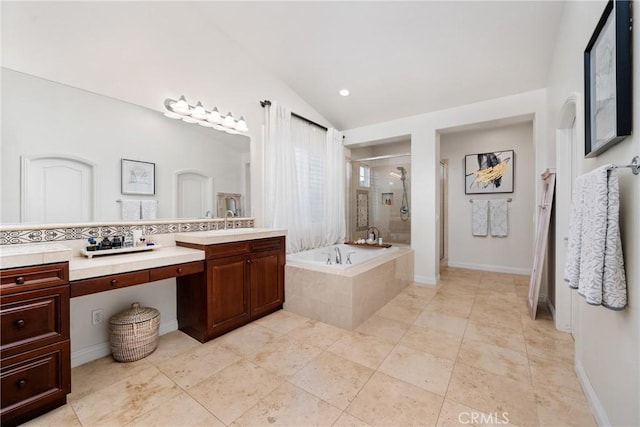 bathroom featuring lofted ceiling, vanity, plus walk in shower, decorative backsplash, and tile patterned floors