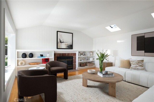 2130 Glenneyre St, Laguna Beach, CA 92651 - living room featuring wood finished floors, lofted ceiling, a skylight, and a fireplace