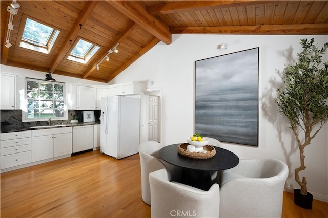 2130 Glenneyre St, Laguna Beach, CA 92651 - kitchen with white appliances, wood ceiling, a sink, dark countertops, and a skylight