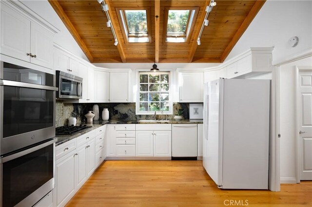 2130 Glenneyre St, Laguna Beach, CA 92651 - kitchen featuring appliances with stainless steel finishes, a skylight, wood ceiling, and white cabinetry