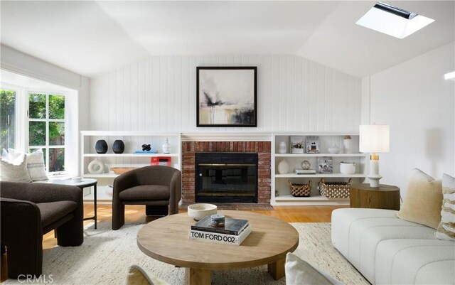2130 Glenneyre St, Laguna Beach, CA 92651 - living room with wood finished floors, lofted ceiling, a skylight, and a brick fireplace