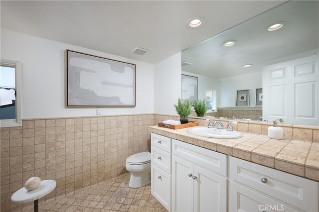 2130 Glenneyre St, Laguna Beach, CA 92651 - bathroom featuring toilet, tile walls, vanity, a wainscoted wall, and recessed lighting