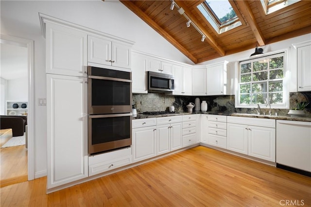 2130 Glenneyre St, Laguna Beach, CA 92651 - kitchen with appliances with stainless steel finishes, rail lighting, light wood finished floors, a skylight, and wood ceiling
