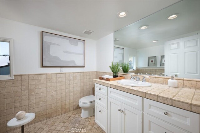 2130 Glenneyre St, Laguna Beach, CA 92651 - bathroom featuring toilet, tile walls, vanity, a wainscoted wall, and recessed lighting