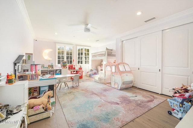 bedroom featuring hardwood / wood-style floors, crown molding, a closet, and ceiling fan