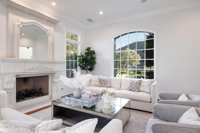 living room featuring crown molding, a high end fireplace, and light hardwood / wood-style floors