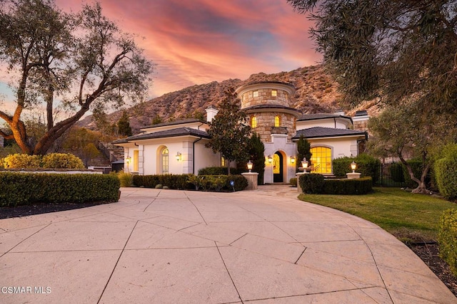 view of front of house featuring a mountain view and a lawn