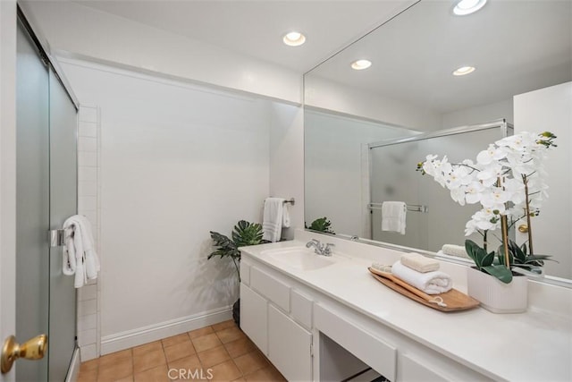 bathroom featuring tile patterned floors, vanity, and a shower with shower door