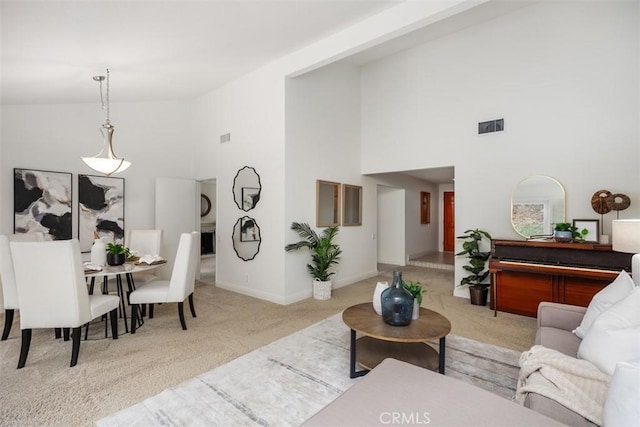 living room featuring high vaulted ceiling and light colored carpet