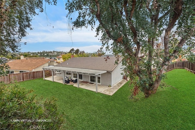 back of house featuring a lawn and a patio