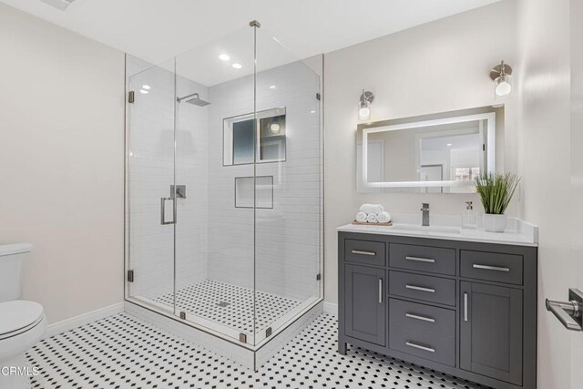 bathroom featuring walk in shower, vanity, and toilet