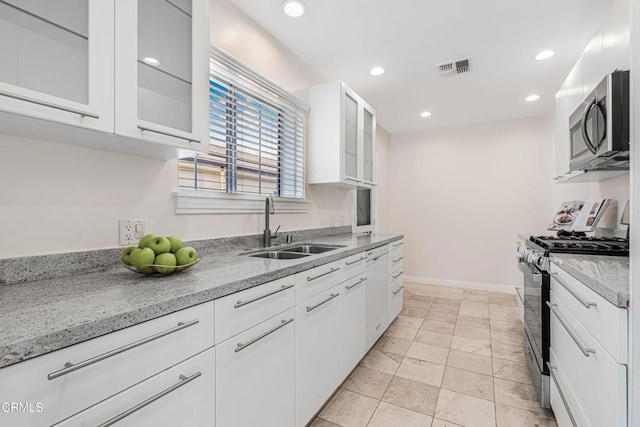 kitchen with white cabinetry, sink, stainless steel appliances, and light stone countertops