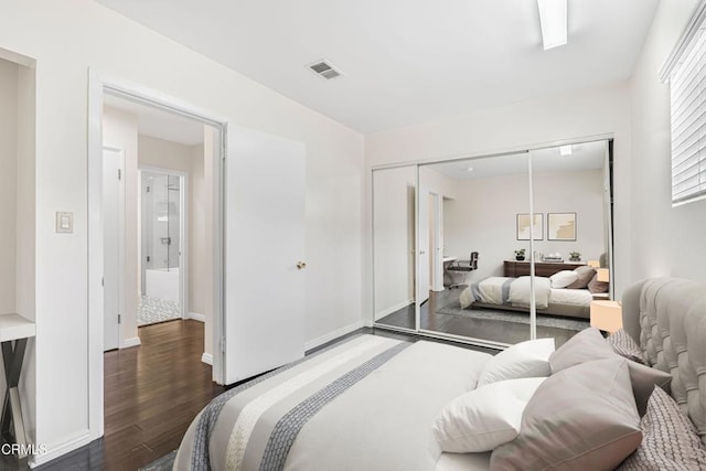 bedroom with dark hardwood / wood-style floors and a closet