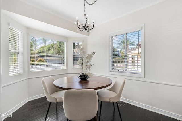 dining room featuring dark wood-type flooring, plenty of natural light, and a chandelier