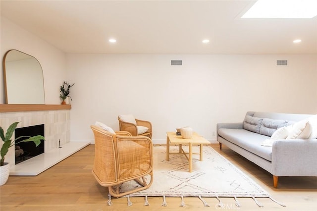 living room with a skylight and hardwood / wood-style floors