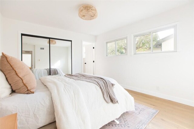 bedroom with a closet, baseboards, and wood finished floors