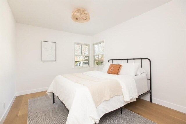 bedroom with wood finished floors and baseboards