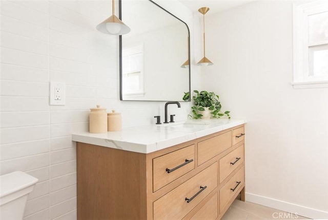 bathroom with vanity, toilet, tile patterned flooring, and tile walls