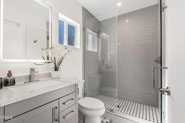 bathroom with vanity, toilet, recessed lighting, and a stall shower