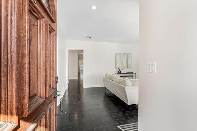 corridor featuring dark wood-style flooring, visible vents, recessed lighting, and baseboards